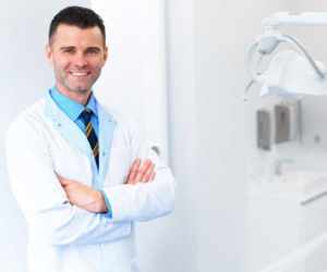 Dentist Doctor Portrait. Young Man at His Workplace. Dental Clin